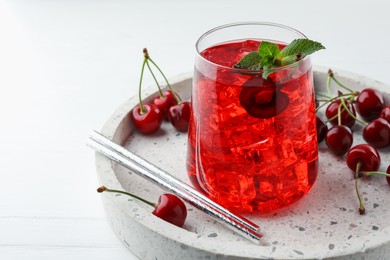 Photo of Tasty cherry soda with ice cubes, mint and berries on white wooden table, closeup. Space for text
