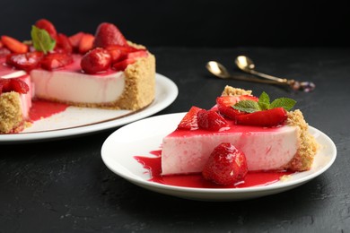 Photo of Delicious cheesecake with strawberries, sauce and mint on black table, closeup