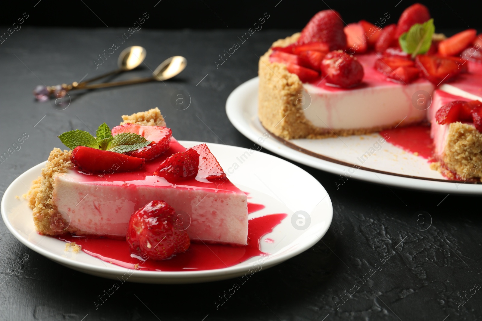 Photo of Delicious cheesecake with strawberries, sauce and mint on black table, closeup