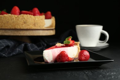 Photo of Piece of tasty cheesecake with strawberries, sauce, mint and coffee on black table, closeup