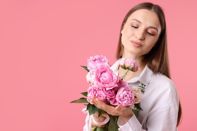 Photo of Florist with beautiful peonies on pink background, space for text