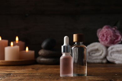 Photo of Spa composition with cosmetic products on wooden table against black background, closeup