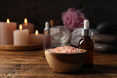 Photo of Spa composition with cosmetic products on wooden table against black background, closeup
