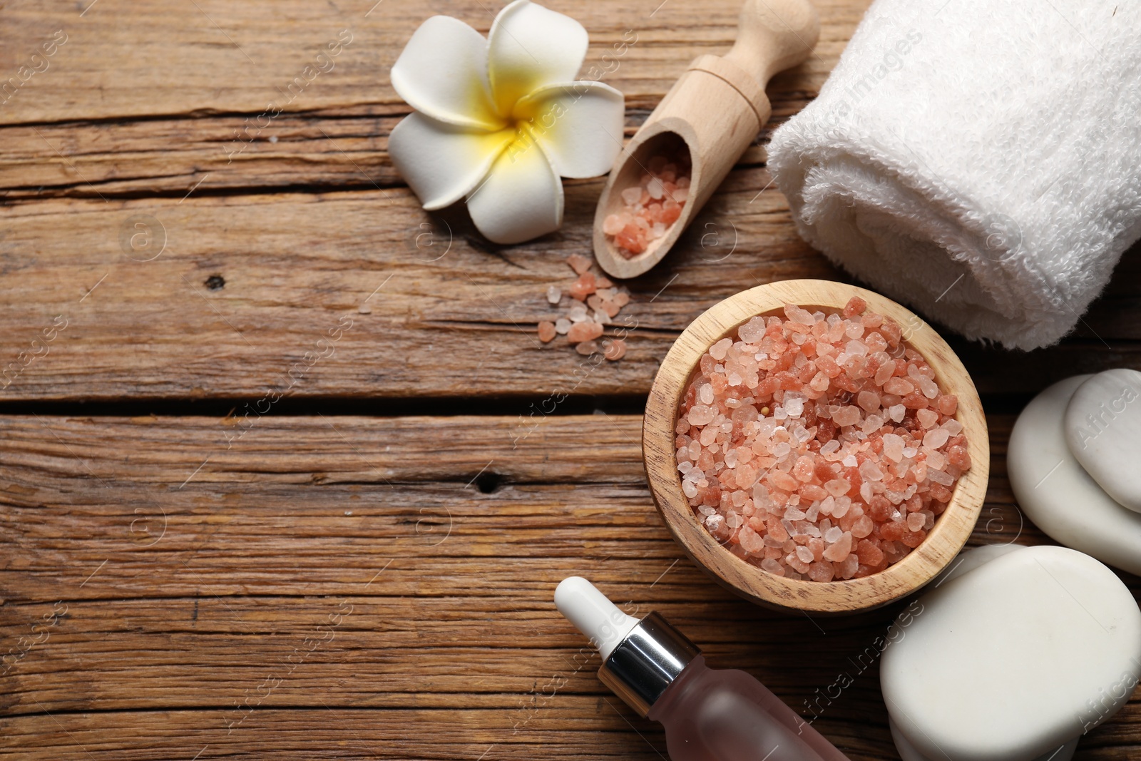 Flat lay composition with spa stones, cosmetic products and flower on wooden table. Space for text Photo of Flat lay composition with spa stones, cosmetic products and flower on wooden table. Space for text