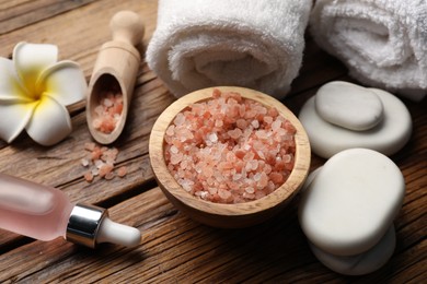 Photo of Spa products and towels on wooden table, closeup