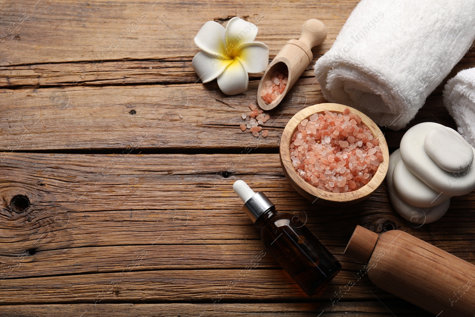 Photo of Spa products and towels on wooden table, above view. Space for text