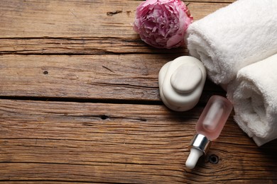 Photo of Spa products and flower on wooden table, above view. Space for text