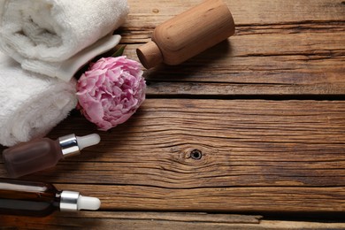 Photo of Spa products and towels on wooden table, above view. Space for text