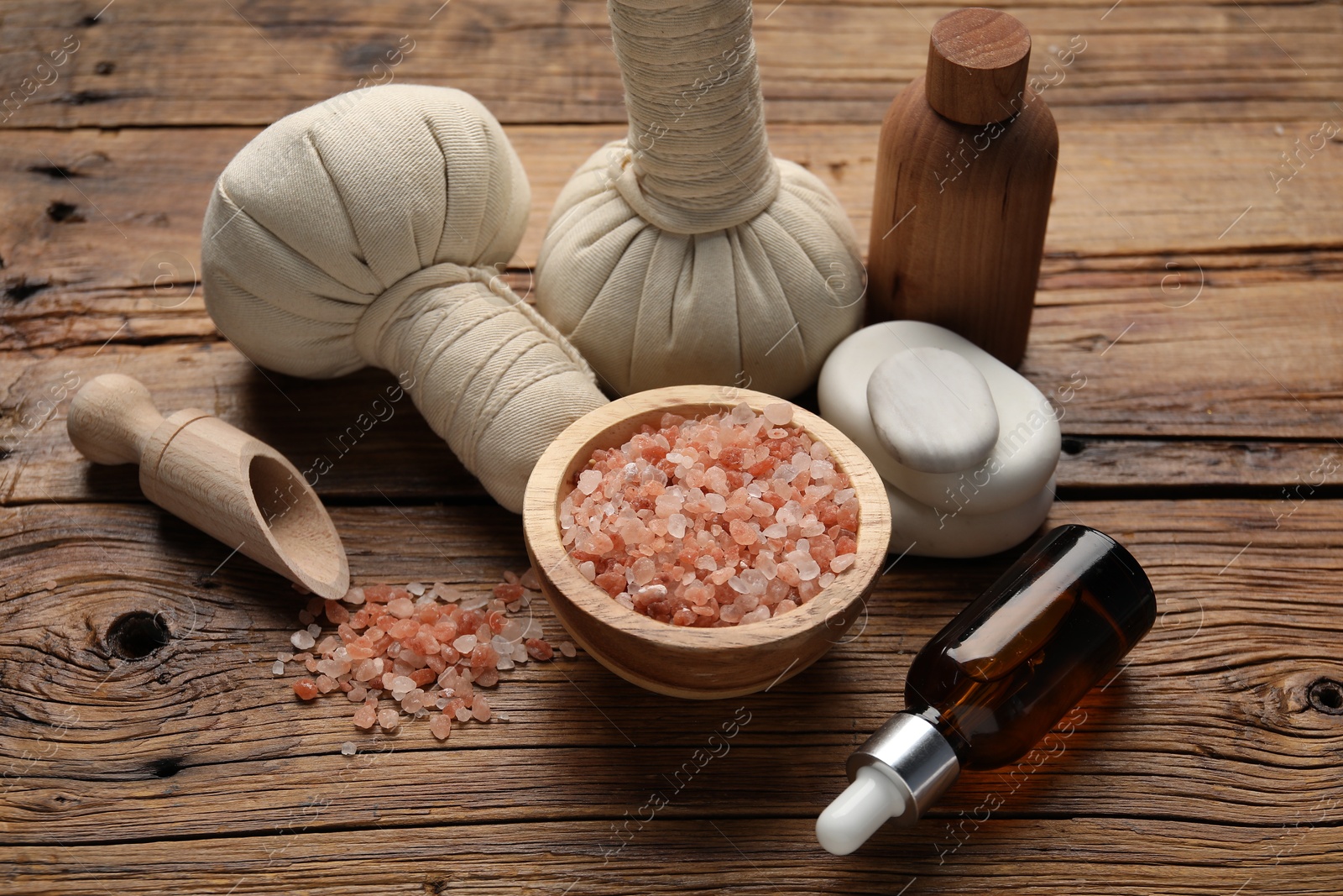 Spa products and herbal bags on wooden table Photo of Spa products and herbal bags on wooden table