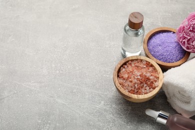 Photo of Spa products, flower and towel on grey textured table. Space for text