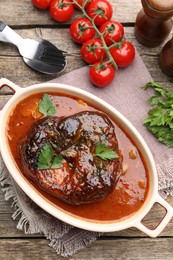 Photo of Traditional ossobuco dish with beef steak served on wooden table, flat lay