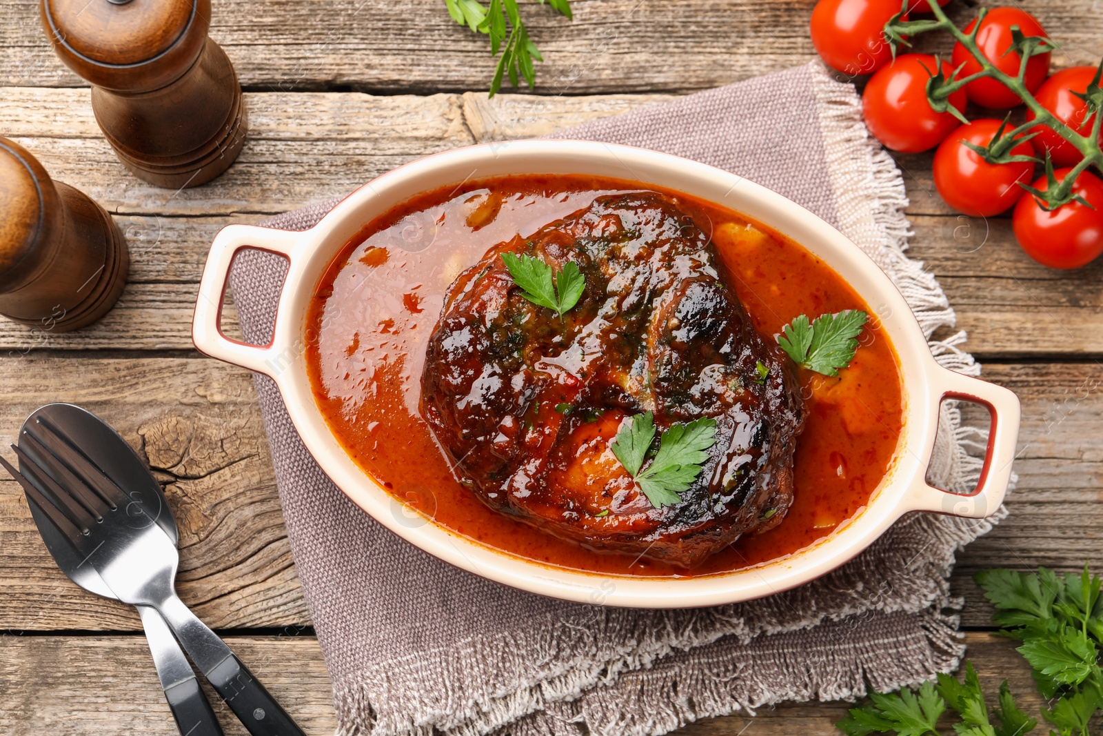 Traditional ossobuco dish with beef steak served on wooden table, flat lay Photo of Traditional ossobuco dish with beef steak served on wooden table, flat lay