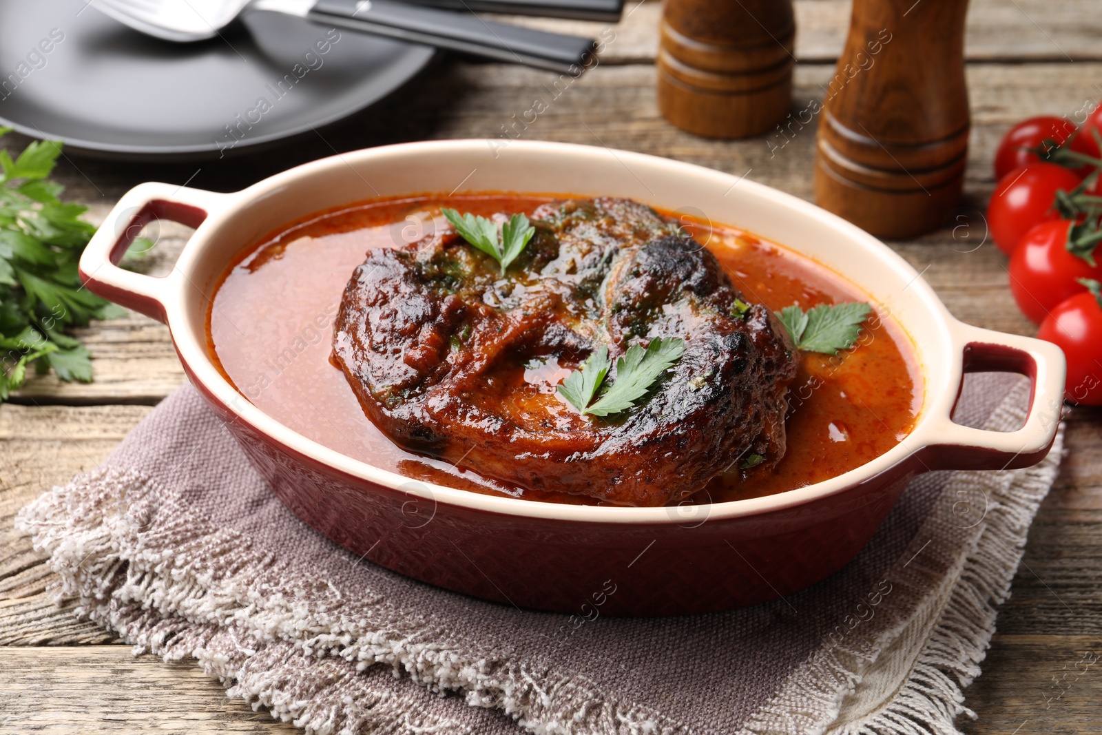 Traditional ossobuco dish with beef steak and sauce served on wooden table, closeup Photo of Traditional ossobuco dish with beef steak and sauce served on wooden table, closeup