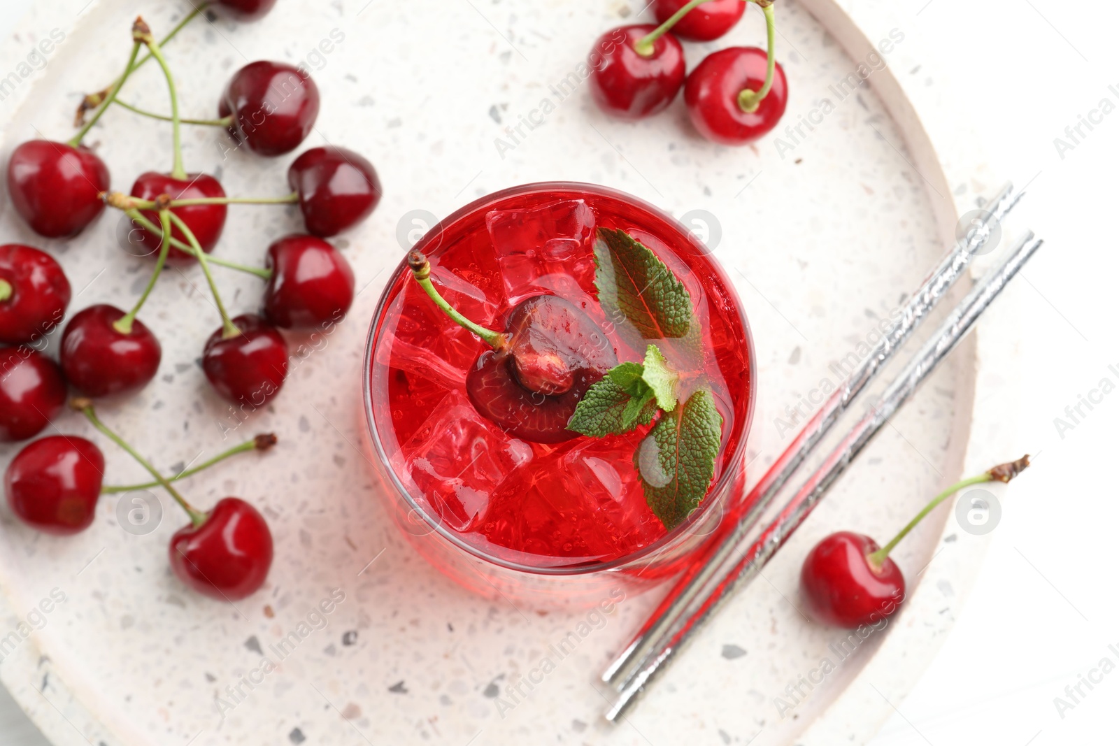 Tasty cherry soda with ice cubes, mint and berries on white wooden table, flat lay Photo of Tasty cherry soda with ice cubes, mint and berries on white wooden table, flat lay