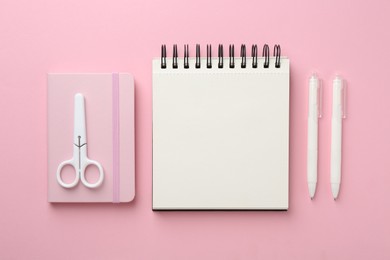 Photo of Notebooks, scissors and pens on pink background, flat lay