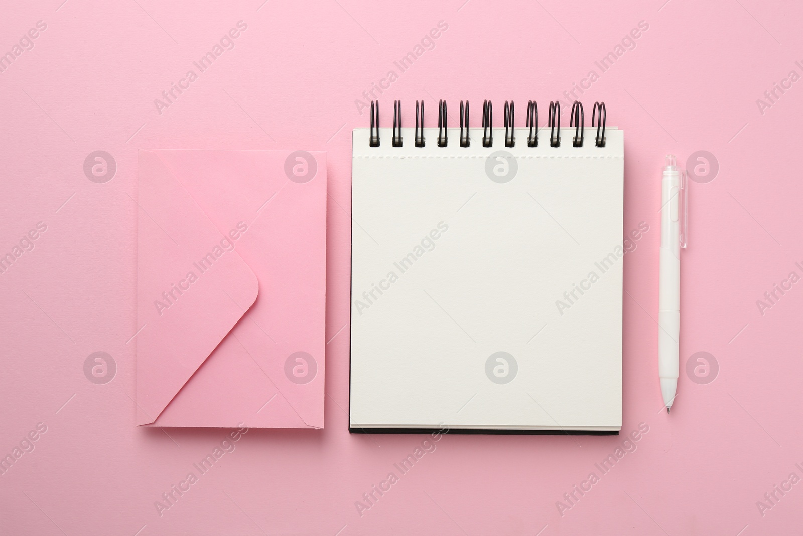 Photo of Notebooks and pens on pink background, flat lay
