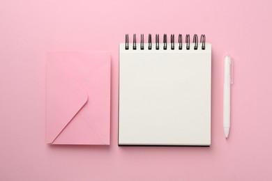 Photo of Notebooks and pens on pink background, flat lay