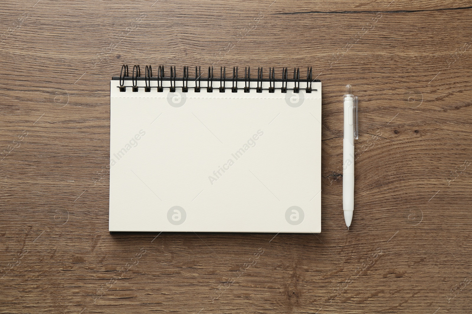 Photo of Notebook and pen on wooden table, flat lay