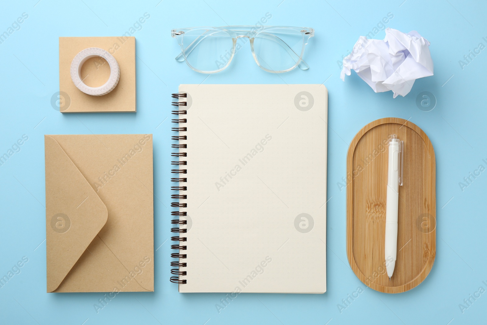 Photo of Flat lay composition with notebook on light blue background
