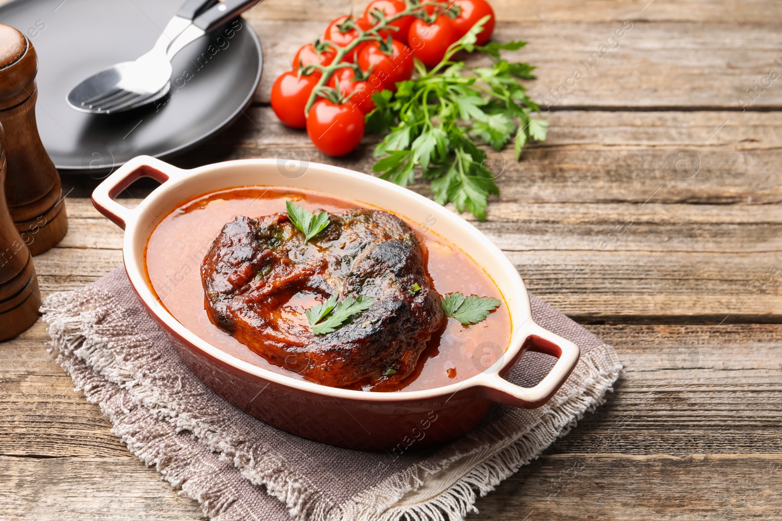 Traditional ossobuco dish with beef steak and sauce served on wooden table, above view. Space for text Photo of Traditional ossobuco dish with beef steak and sauce served on wooden table, above view. Space for text