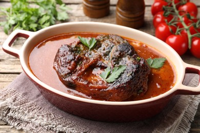 Photo of Traditional ossobuco dish with beef steak and sauce served on table, closeup