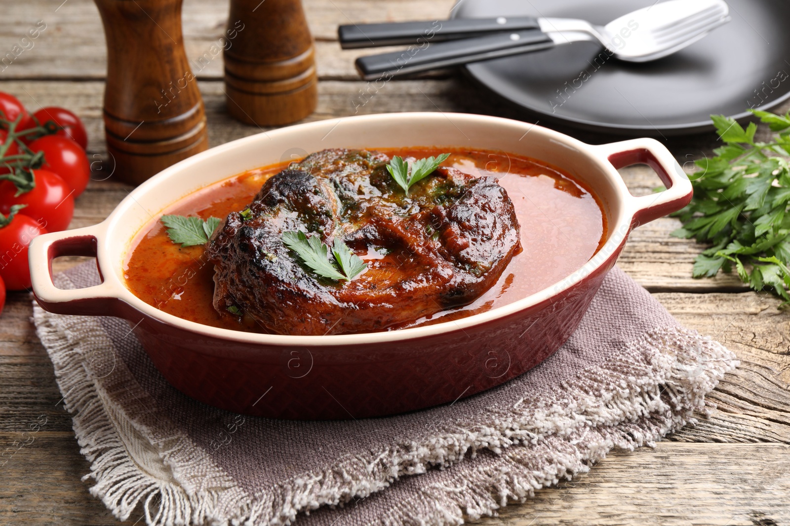 Traditional ossobuco dish with beef steak and sauce served on wooden table, closeup Photo of Traditional ossobuco dish with beef steak and sauce served on wooden table, closeup
