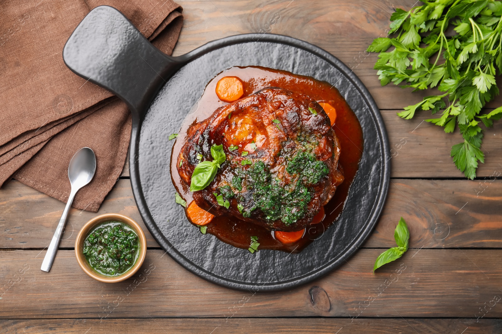 Traditional ossobuco dish with beef steak and sauce served on wooden table, flat lay Photo of Traditional ossobuco dish with beef steak and sauce served on wooden table, flat lay