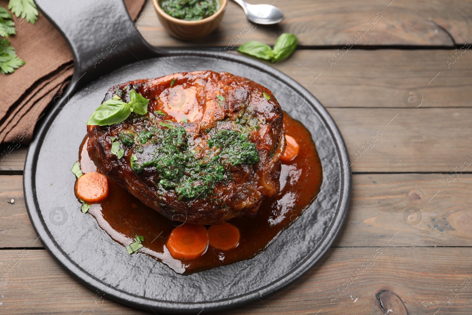 Traditional ossobuco dish with beef steak and sauce served on wooden table, above view. Space for text Photo of Traditional ossobuco dish with beef steak and sauce served on wooden table, above view. Space for text