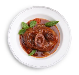 Photo of Traditional ossobuco dish with beef steak, sauce and basil isolated on white, top view