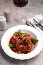 Photo of Traditional ossobuco dish with beef steak served on grey table, above view