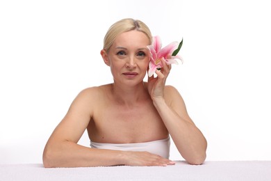 Photo of Beautiful woman with lily flower and towel on white background