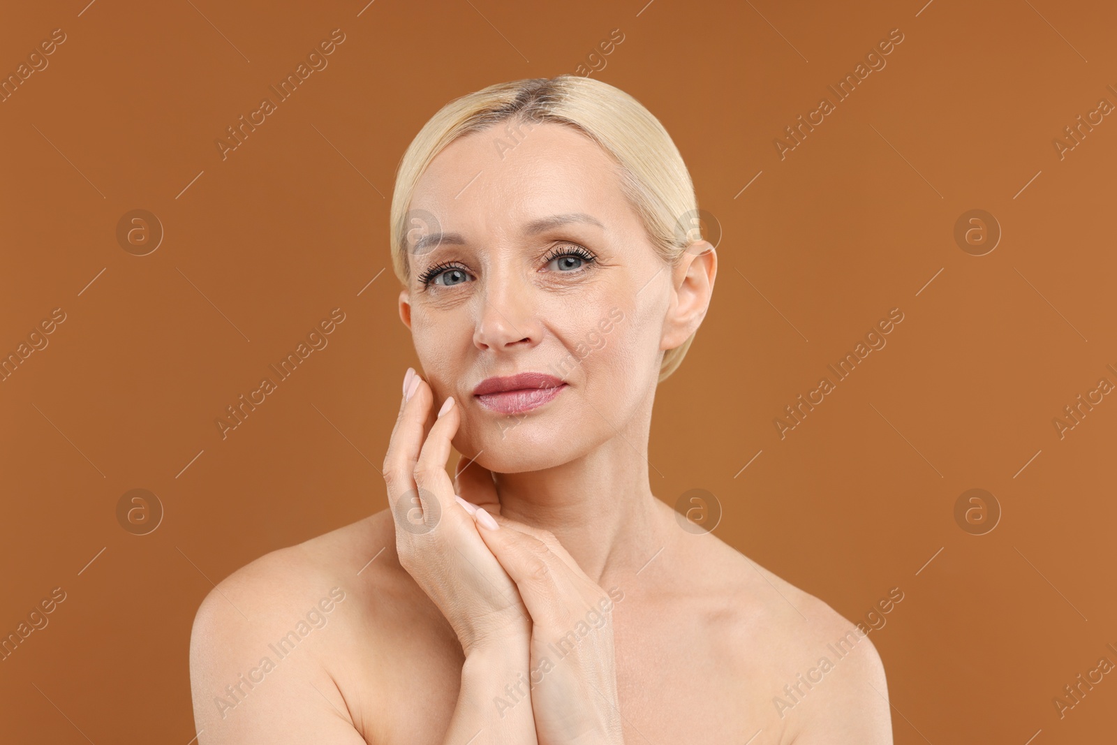Portrait of beautiful woman on brown background Photo of Portrait of beautiful woman on brown background