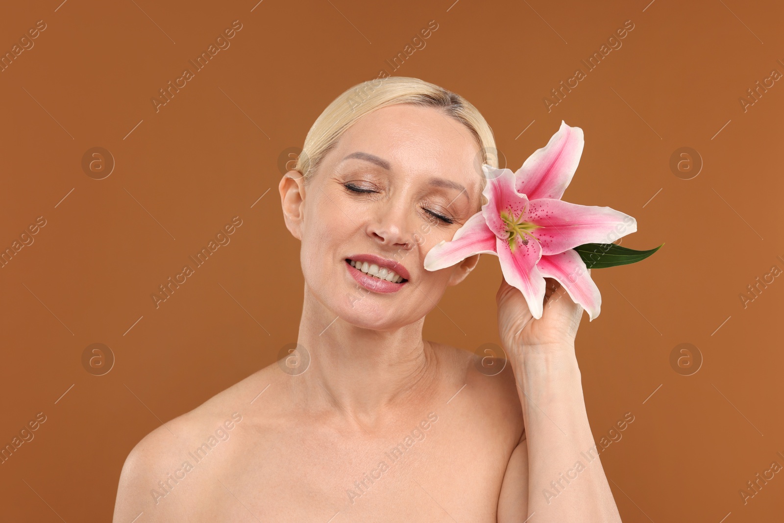 Beautiful woman with lily flower on brown background Photo of Beautiful woman with lily flower on brown background