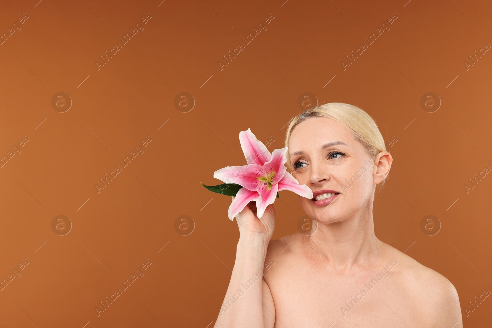 Beautiful woman with lily flower on brown background. Space for text Photo of Beautiful woman with lily flower on brown background. Space for text
