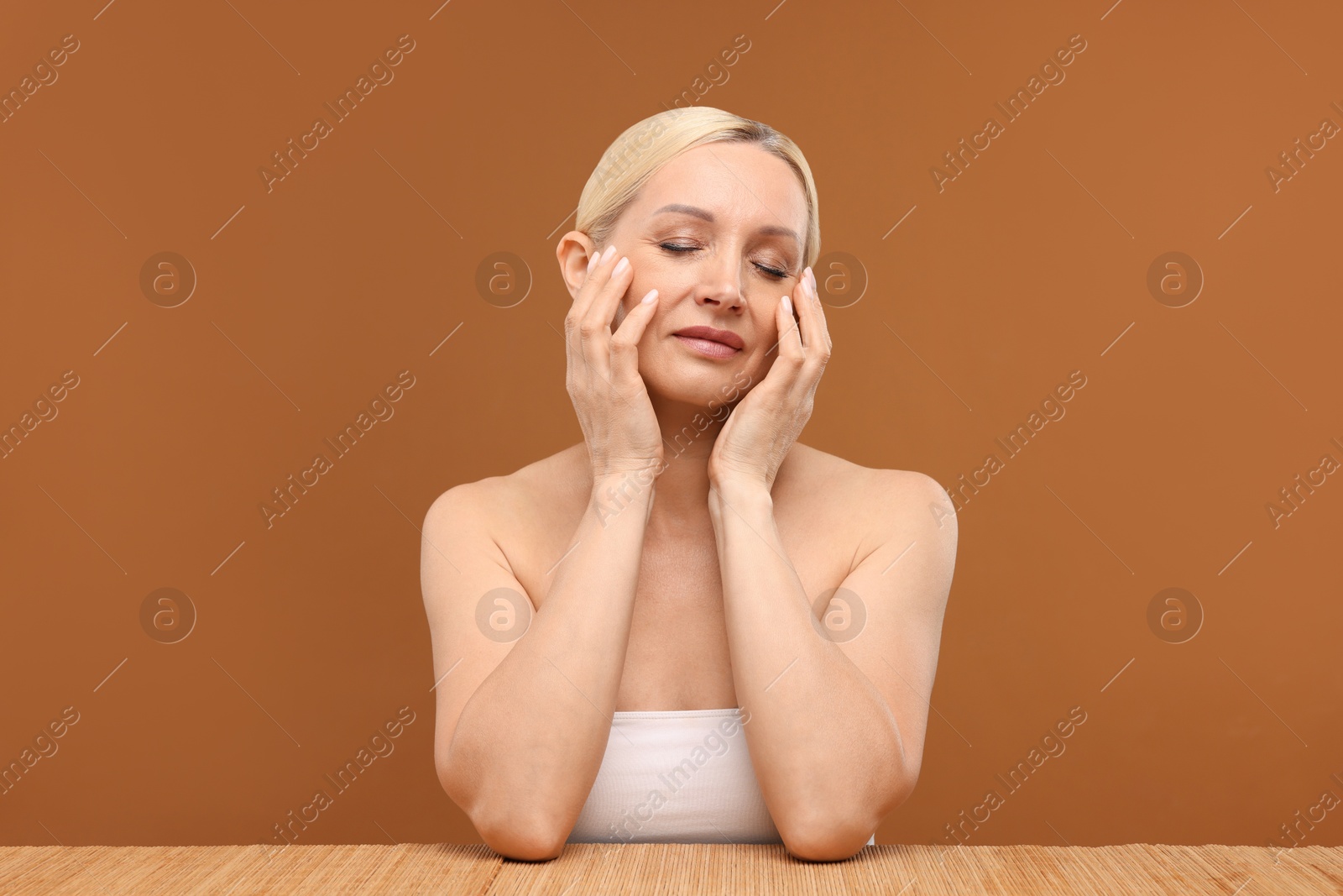 Portrait of beautiful woman on brown background Photo of Portrait of beautiful woman on brown background