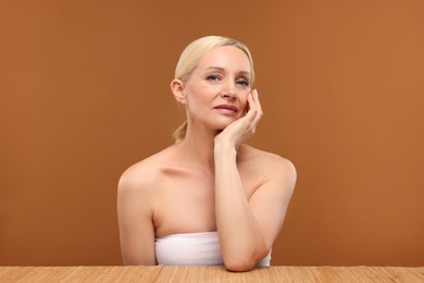 Photo of Portrait of beautiful woman on brown background