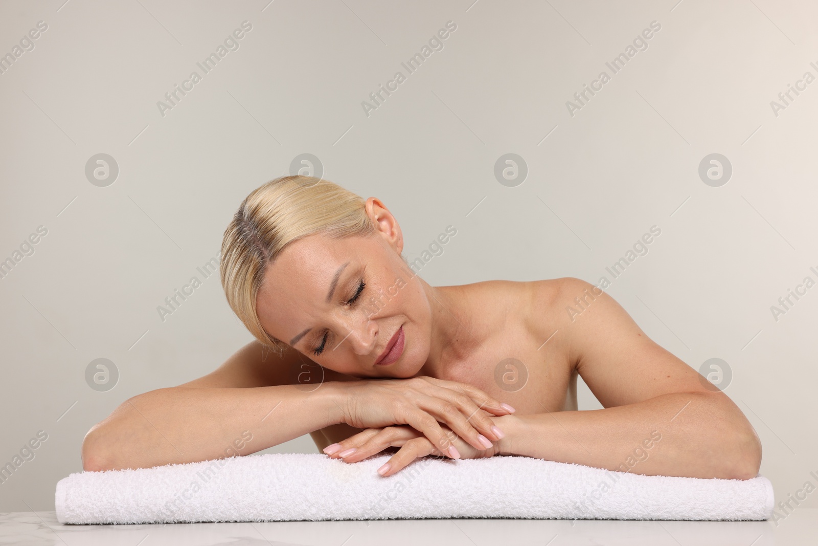 Beautiful woman with towel on light background. Space for text Photo of Beautiful woman with towel on light background. Space for text