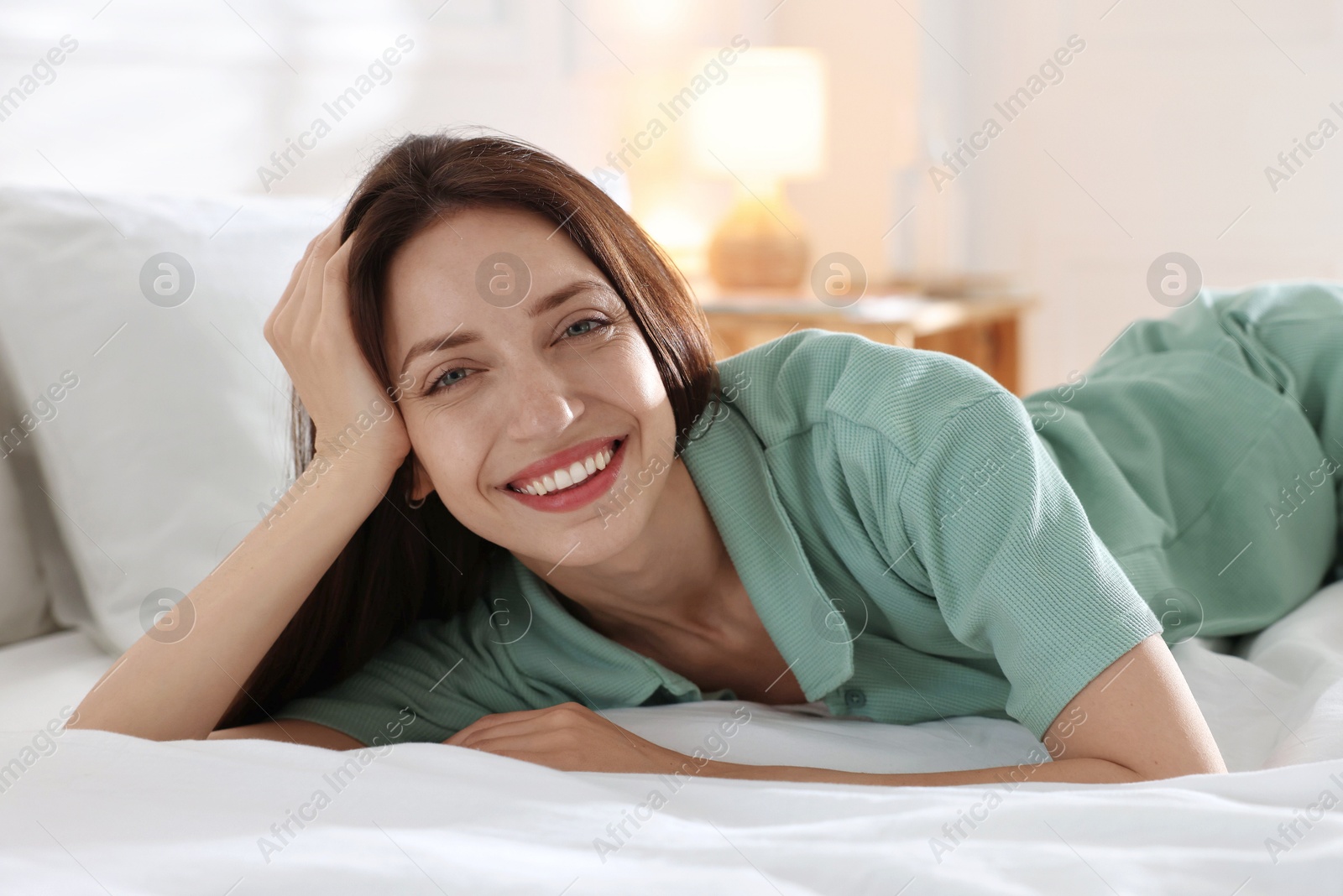 Woman lying on bed with soft mattress at home Photo of Woman lying on bed with soft mattress at home