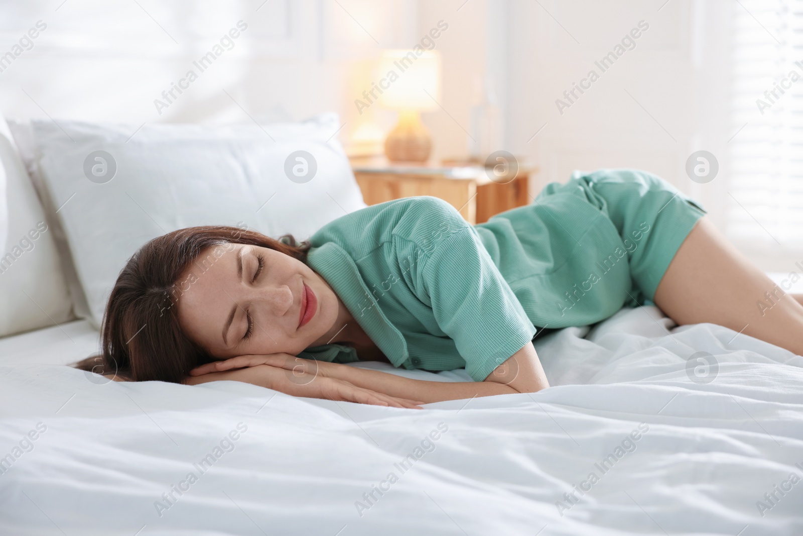 Woman sleeping on bed with soft mattress at home Photo of Woman sleeping on bed with soft mattress at home