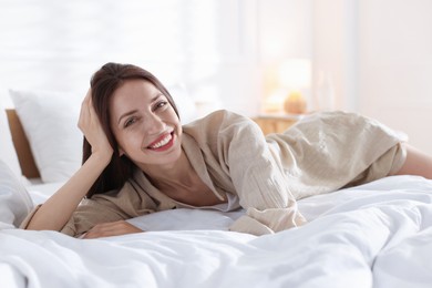 Photo of Woman lying on bed with soft mattress at home