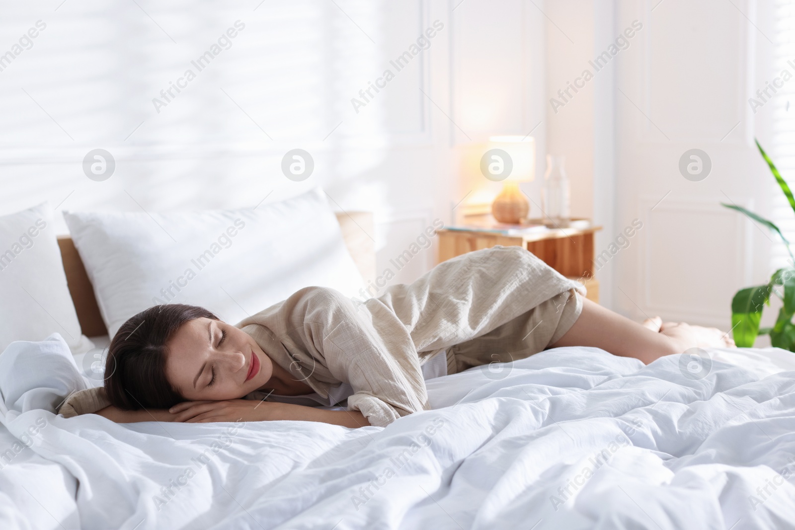 Woman sleeping on bed with soft mattress at home. Space for text Photo of Woman sleeping on bed with soft mattress at home. Space for text