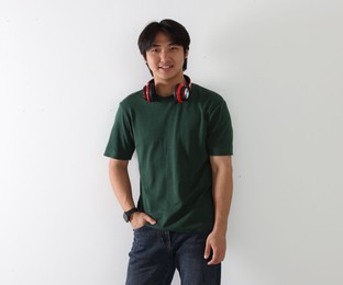 Photo of Smiling Asian man with headphones on white background