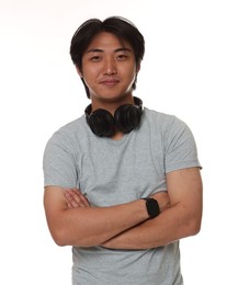 Photo of Portrait of handsome Asian man with headphones on white background