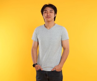 Photo of Portrait of handsome Asian man on yellow background
