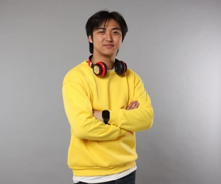 Photo of Handsome Asian man with headphones on grey background