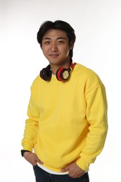 Photo of Portrait of handsome Asian man with headphones on white background
