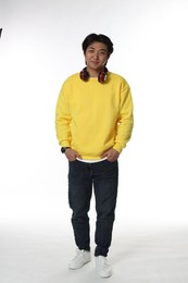 Photo of Handsome Asian man with headphones on white background