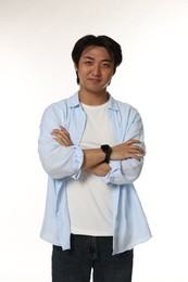 Photo of Portrait of handsome Asian man with crossed arms on white background