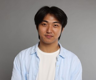 Photo of Portrait of handsome Asian man on grey background