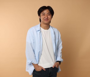 Photo of Portrait of handsome Asian man on beige background